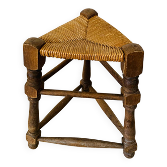 Old tripod stool made of wood and straw