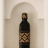 Ethnic decorative bottle in leather and raffia braiding