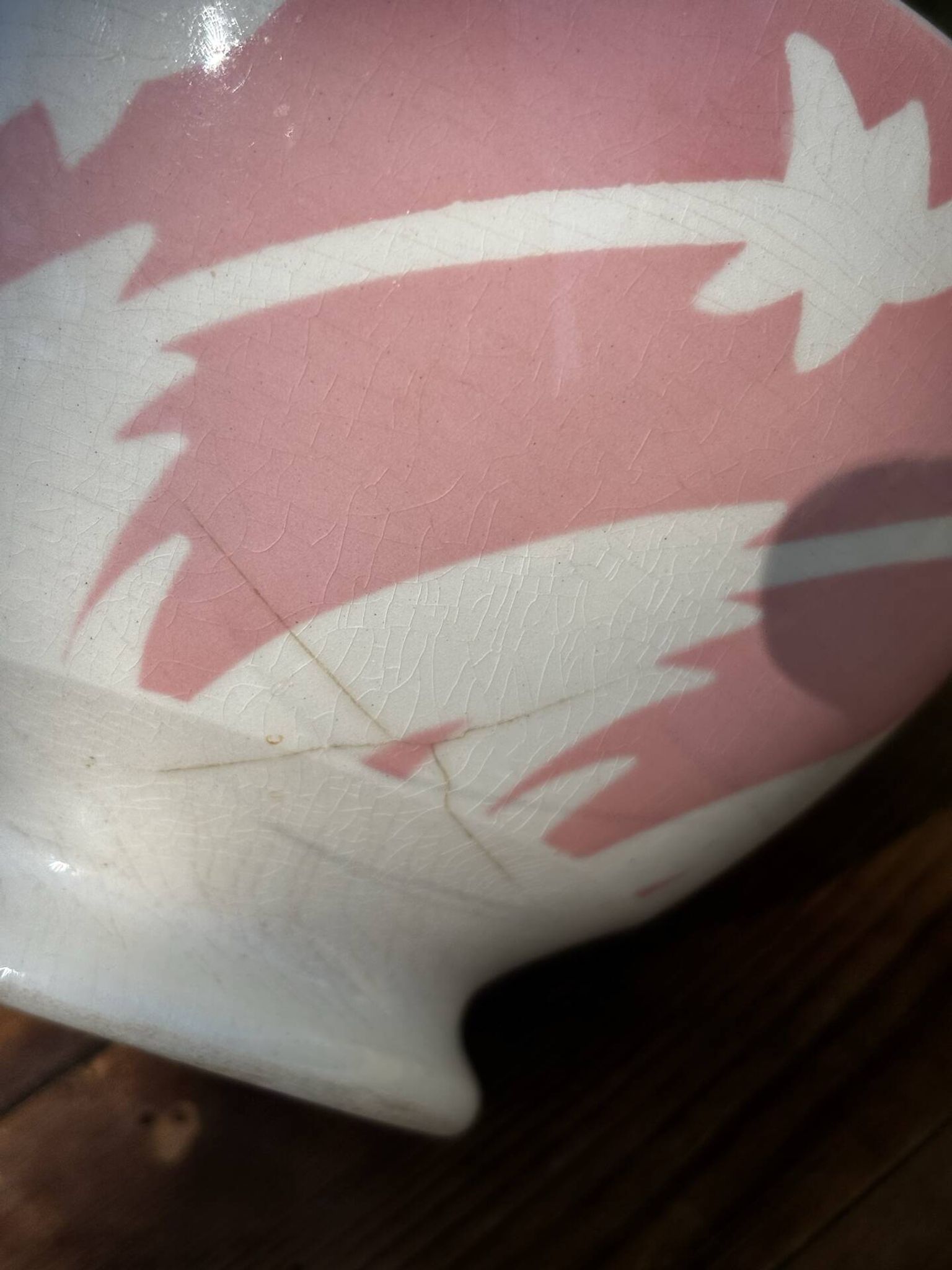Old footed bowl in earthenware with pink decoration and defects.