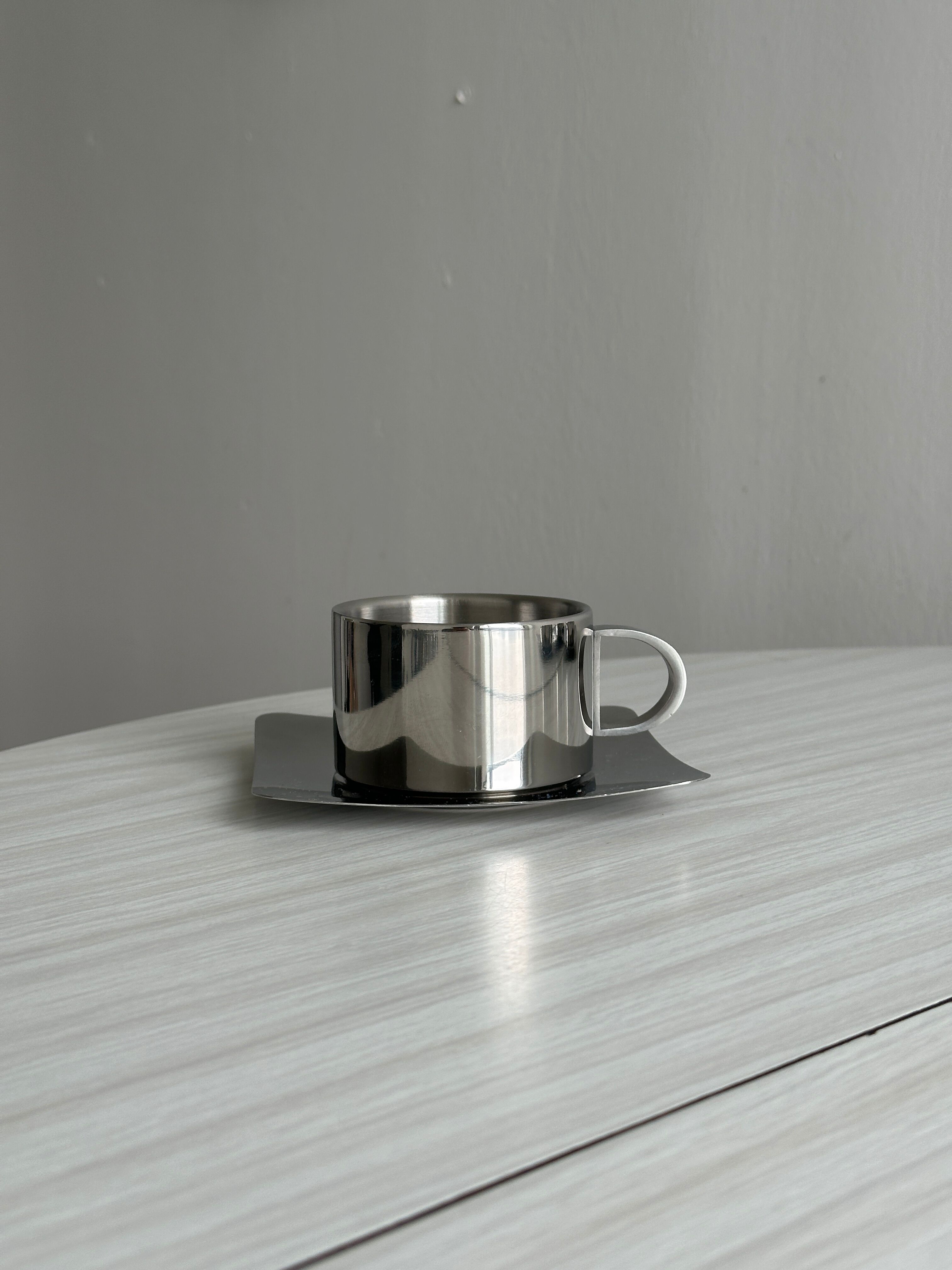set of 4 stackable stainless steel coffee cups with saucers