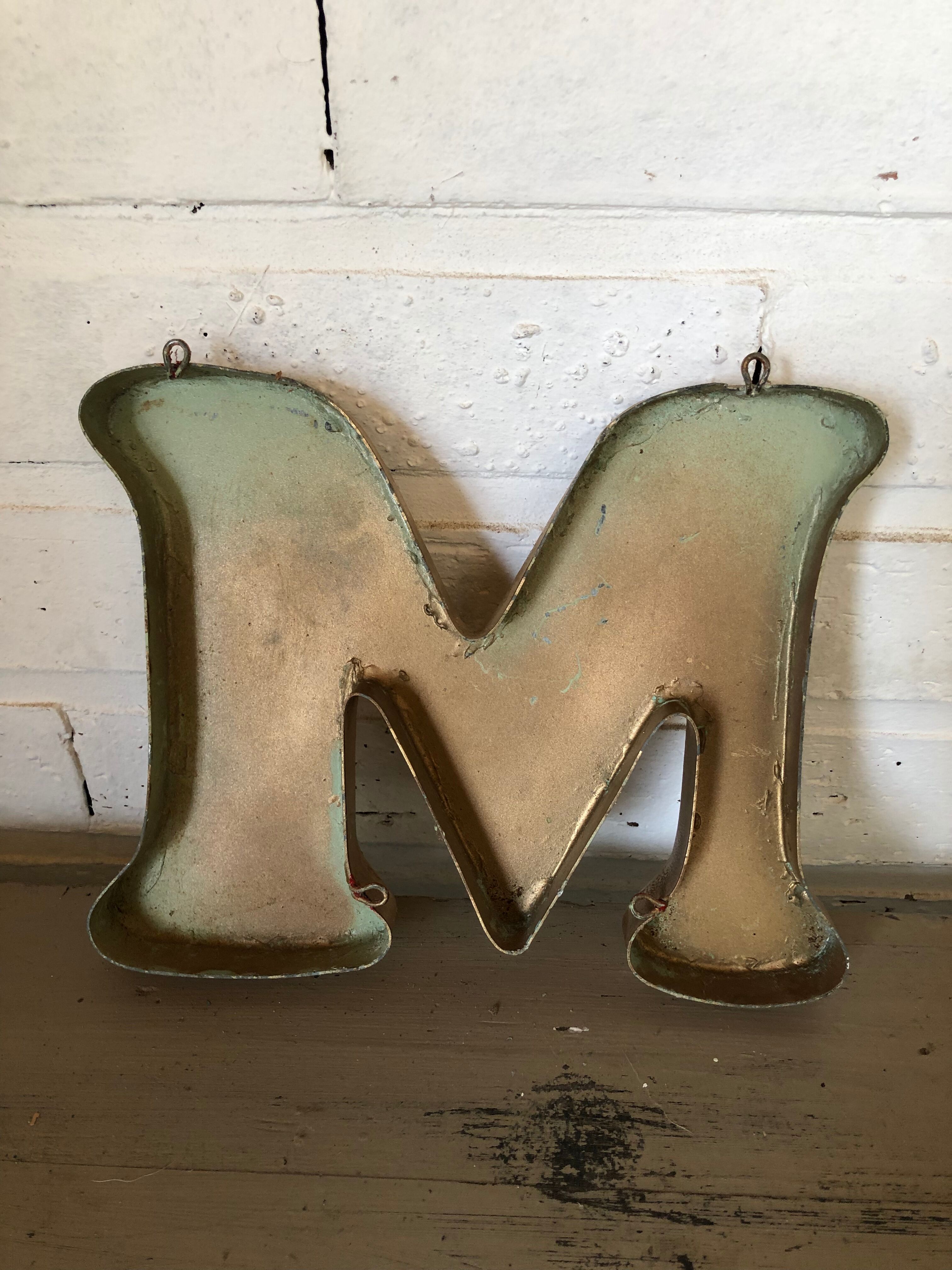 Golden sign letter "M"