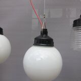 Trio of opal glass and bakelite globe pendant lights