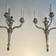 A pair of important Louis XVI style silver-plated wall sconces with three light arms.