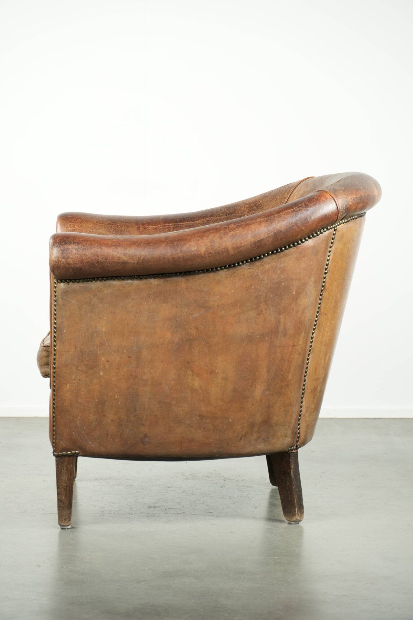 Vintage sheepskin club armchair finished with decorative nails
