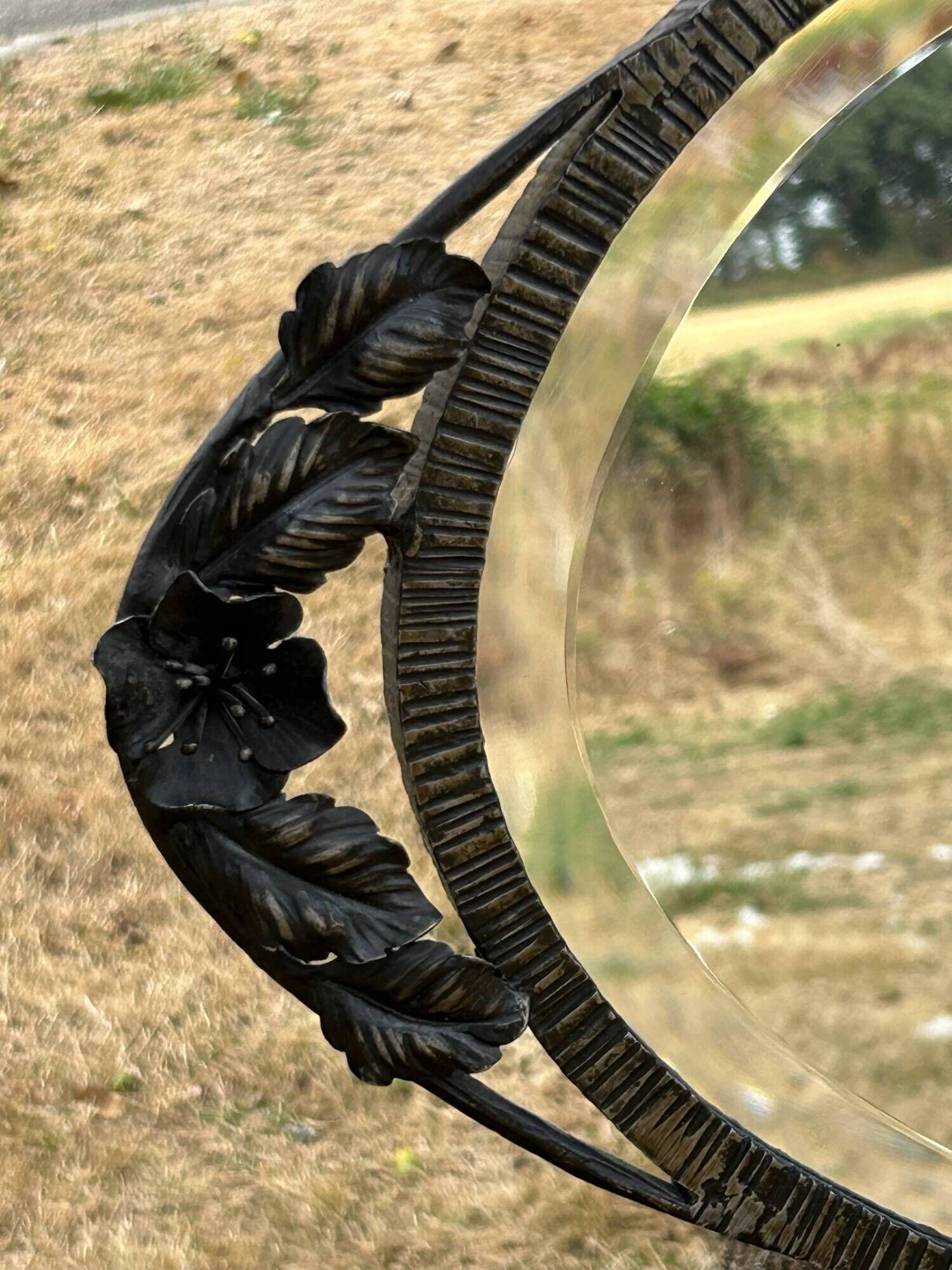 Bevelled oval mirror, richly crafted Art Deco wrought iron.
