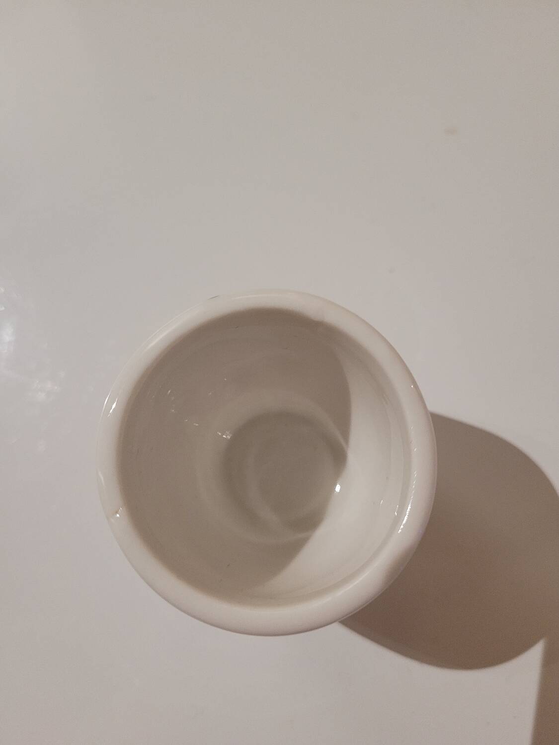 Set of four ceramic egg cups with a floral and fruit pattern.