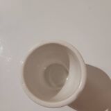 Set of four ceramic egg cups with a floral and fruit pattern.