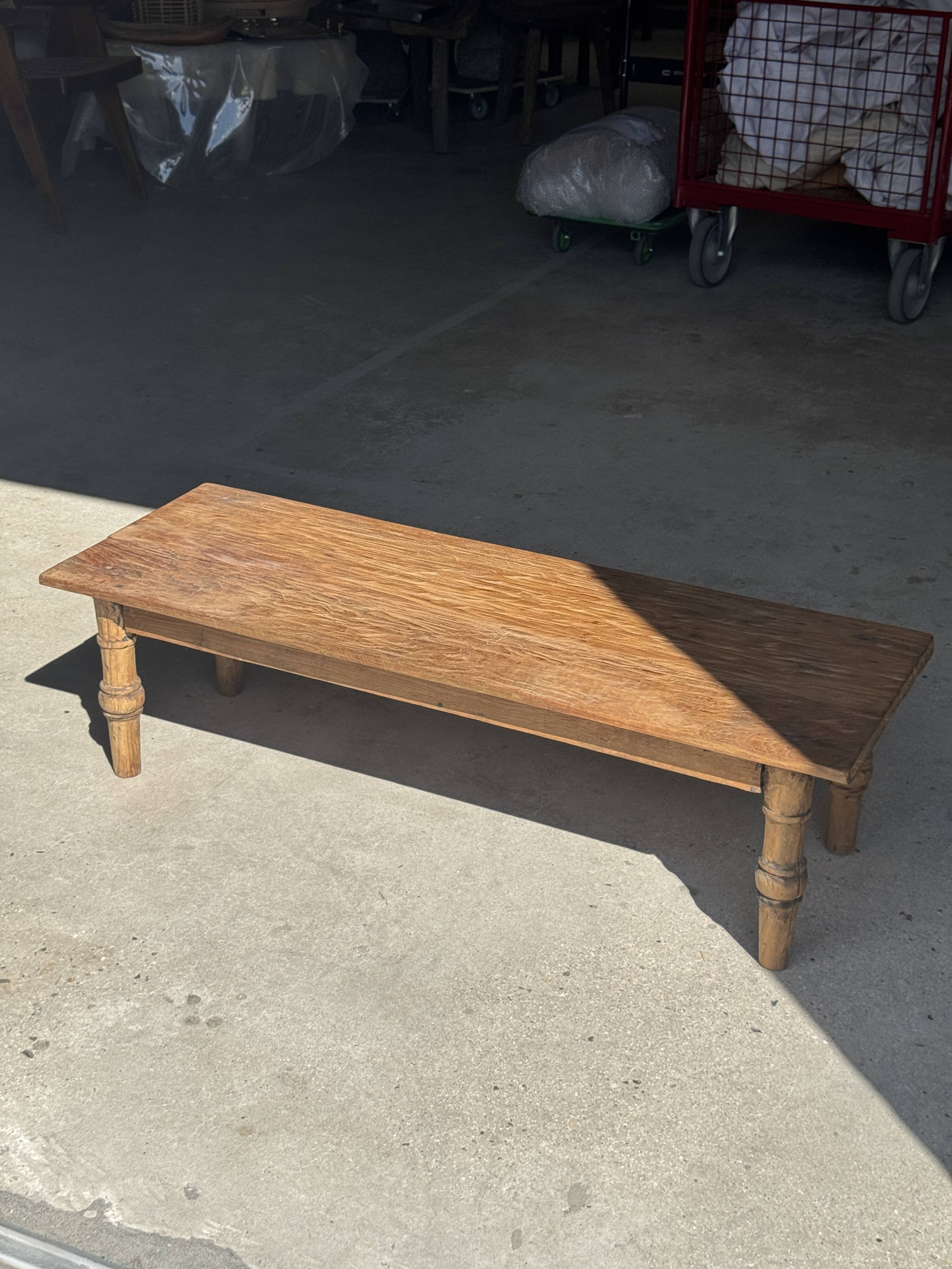 Brown Indonesian teak coffee table, with a border and cylindrical legs H40 L103.
