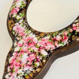 Vintage enameled metal hand mirror on wood