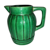 Old green pitcher in dabbling