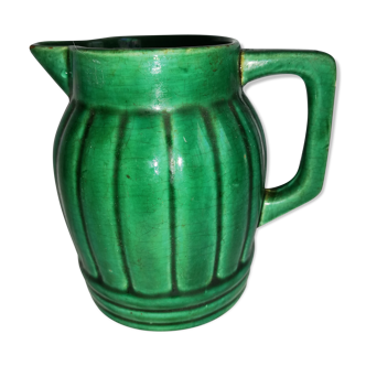Old green pitcher in dabbling