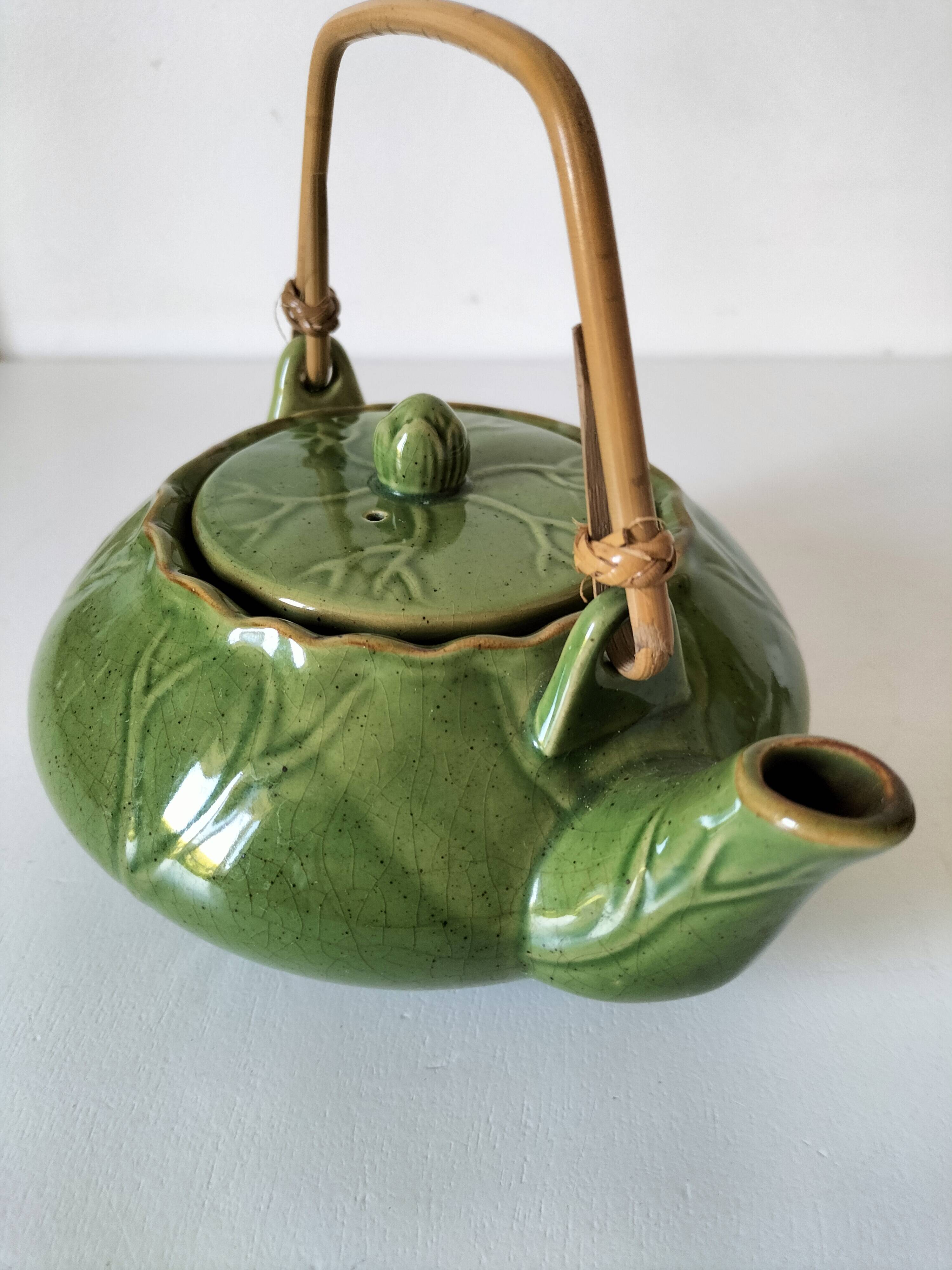 Vintage green teapot with lotus decoration and bamboo handle.