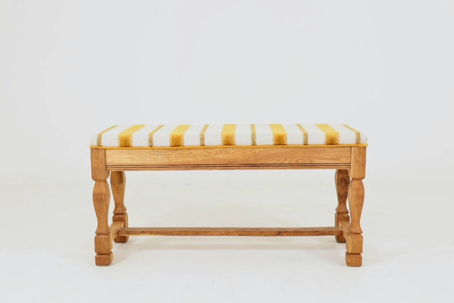 Vintage oak bench with striped linen fabric in a country style.