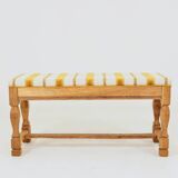 Vintage oak bench with striped linen fabric in a country style.