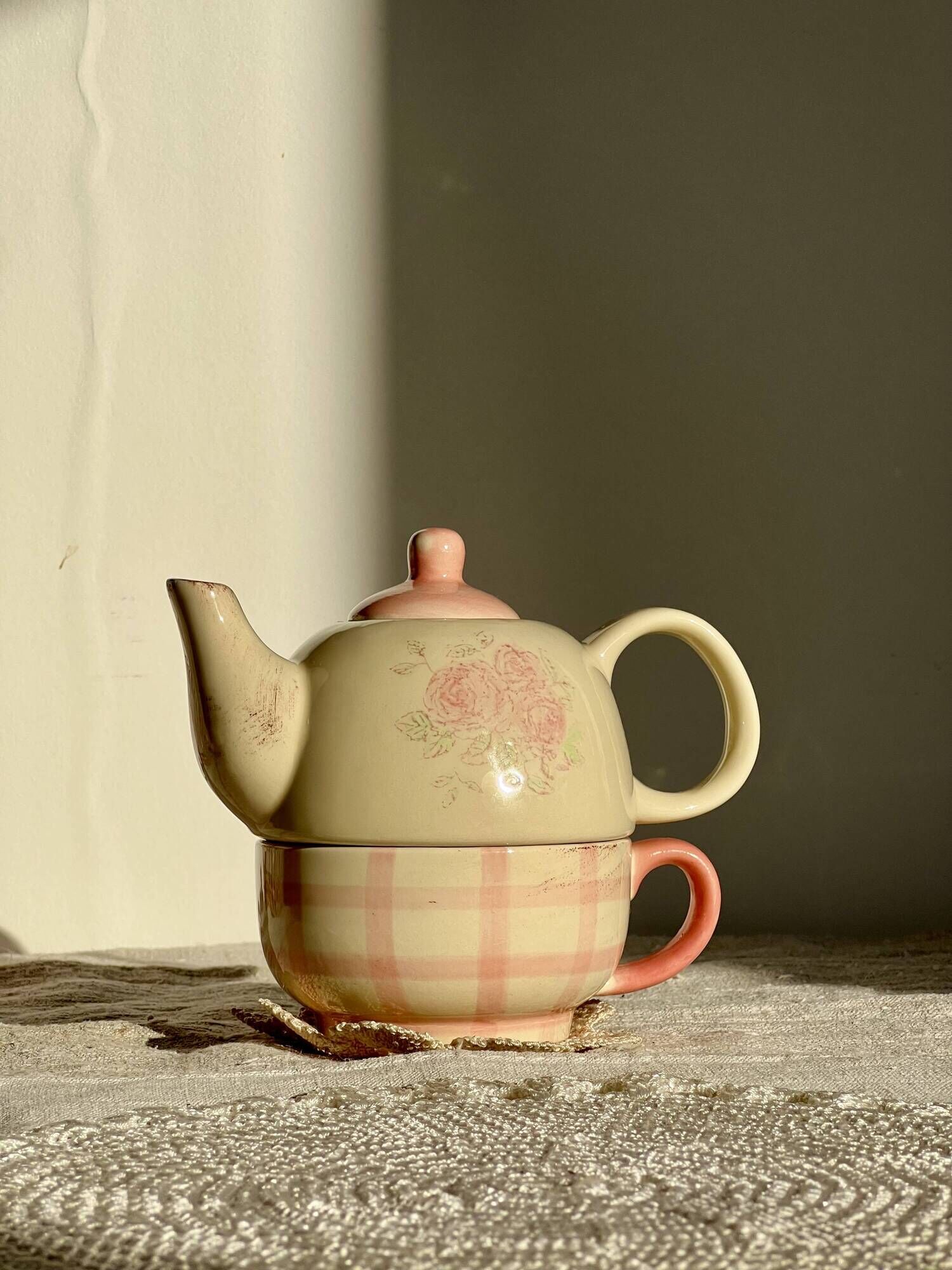 Vintage porcelain teapot and cup set with pink and beige floral and gingham pattern