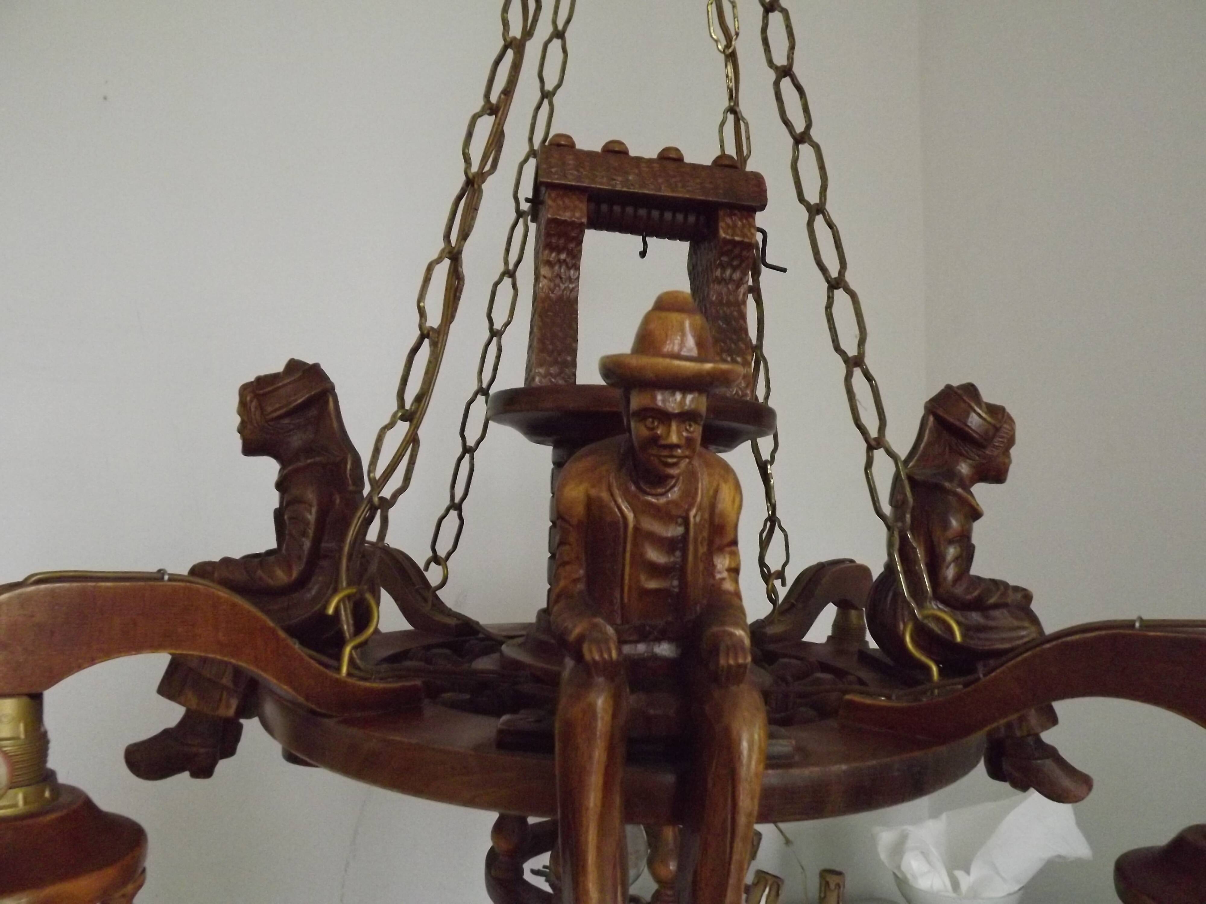 French vintage Breton chandelier with hand-carved figures, well, and lantern lights.