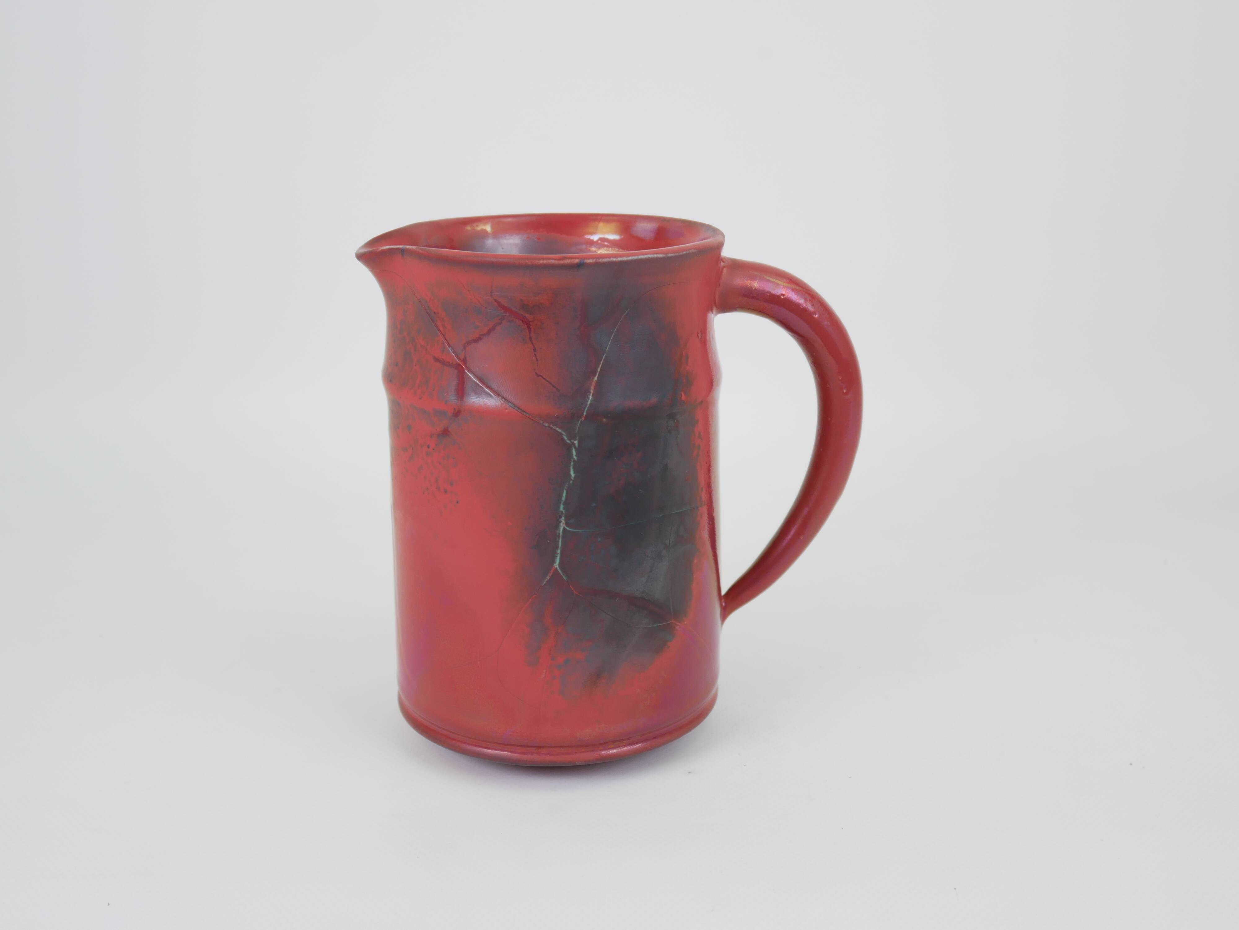Red glazed ceramic jug with relief