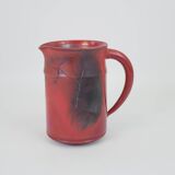 Red glazed ceramic jug with relief