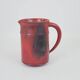 Red glazed ceramic jug with relief