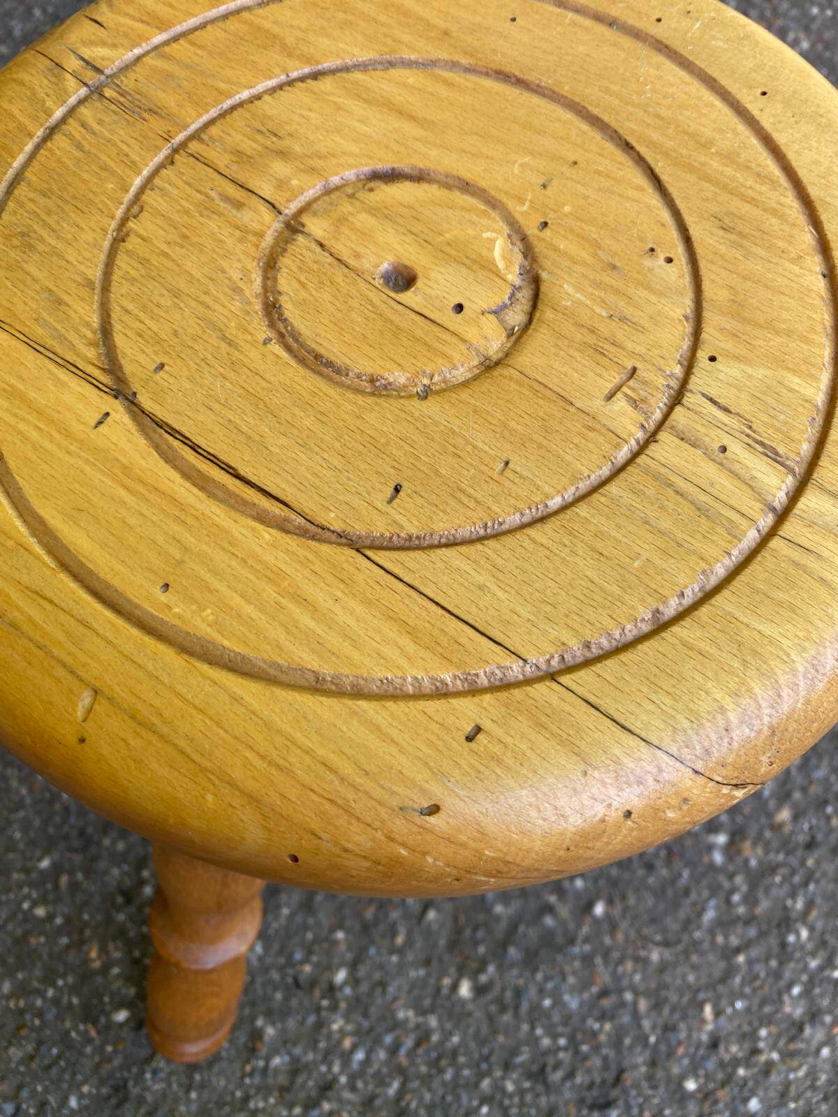 Vintage low tripod stool with carved light oak legs.