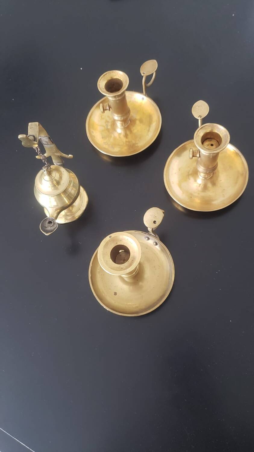 Many candlesticks and a small oil lamp.