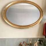 Beveled oval mirror with carved gilded wood frame