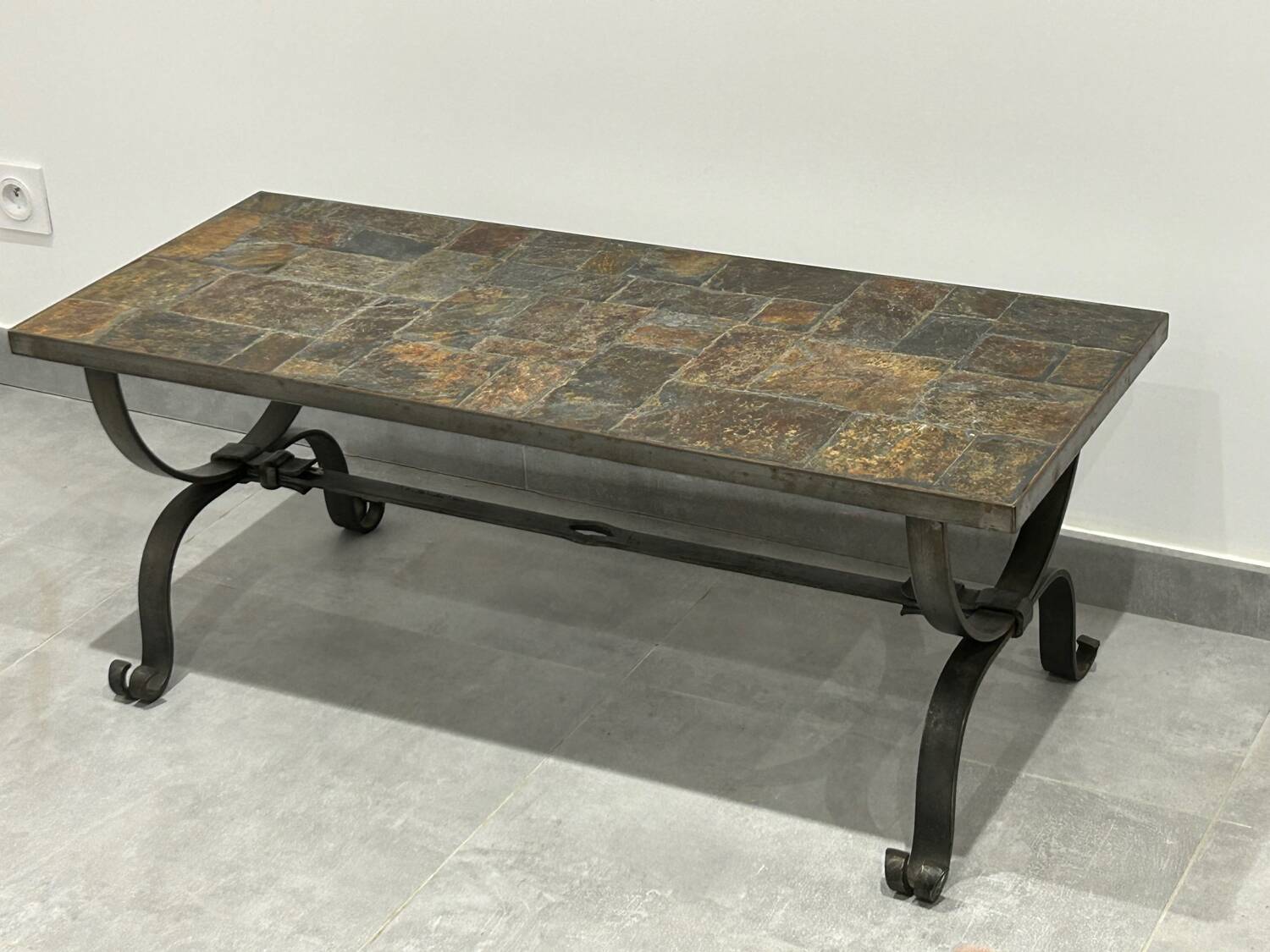 Brutalist-style coffee table made of mixed wrought iron and stone.