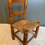 Old, rustic children's chair, small wooden and straw chair.