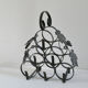 Vintage black wrought iron bottle holder decorated with vine leaves