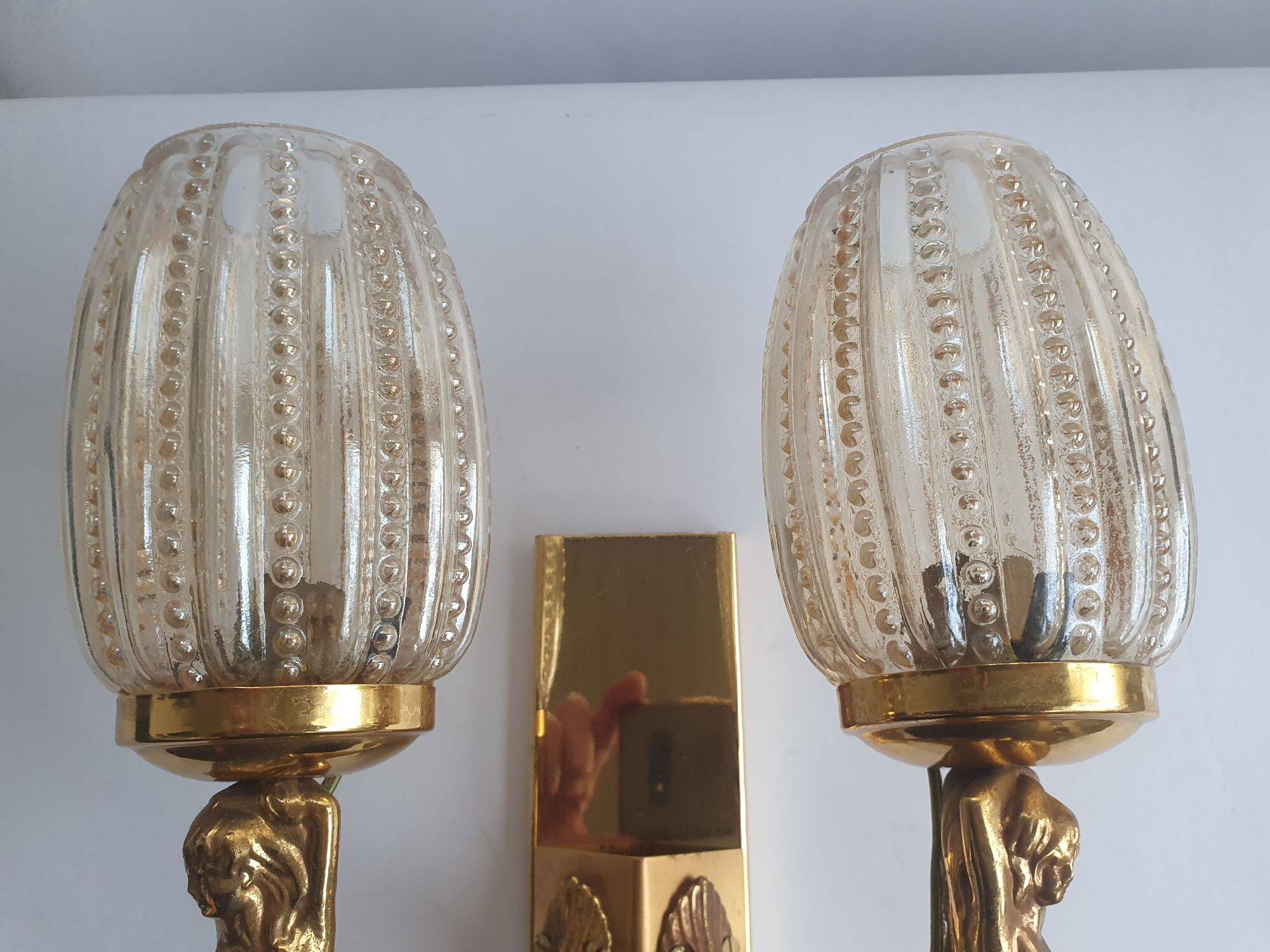 Golden bronze wall lamp with mermaids for an old bathroom.