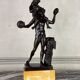 Dionysus on the shoulders of a satyr, bronze after the antique on a yellow Siena base.