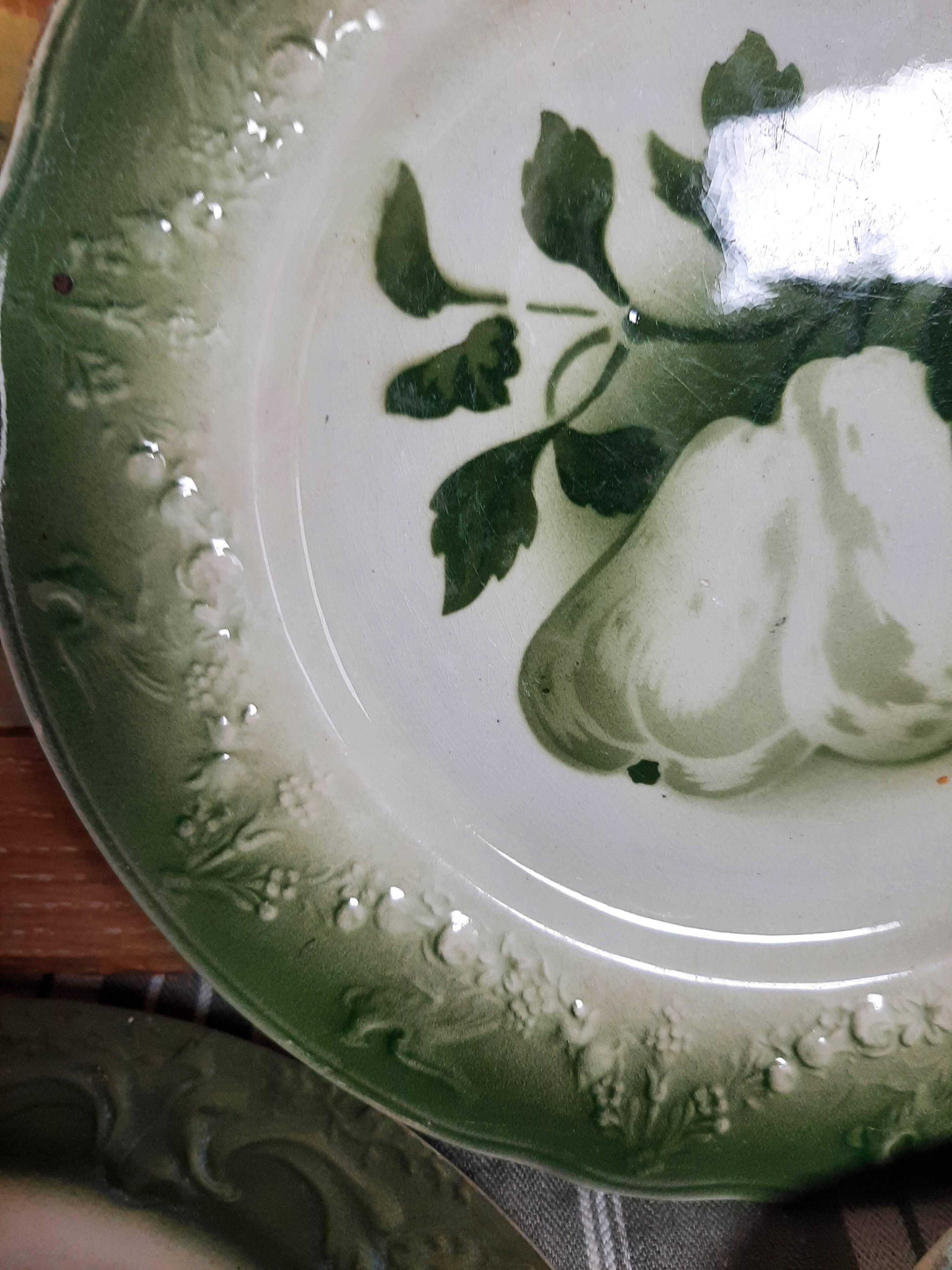 Antique earthenware plates with fruit decoration.