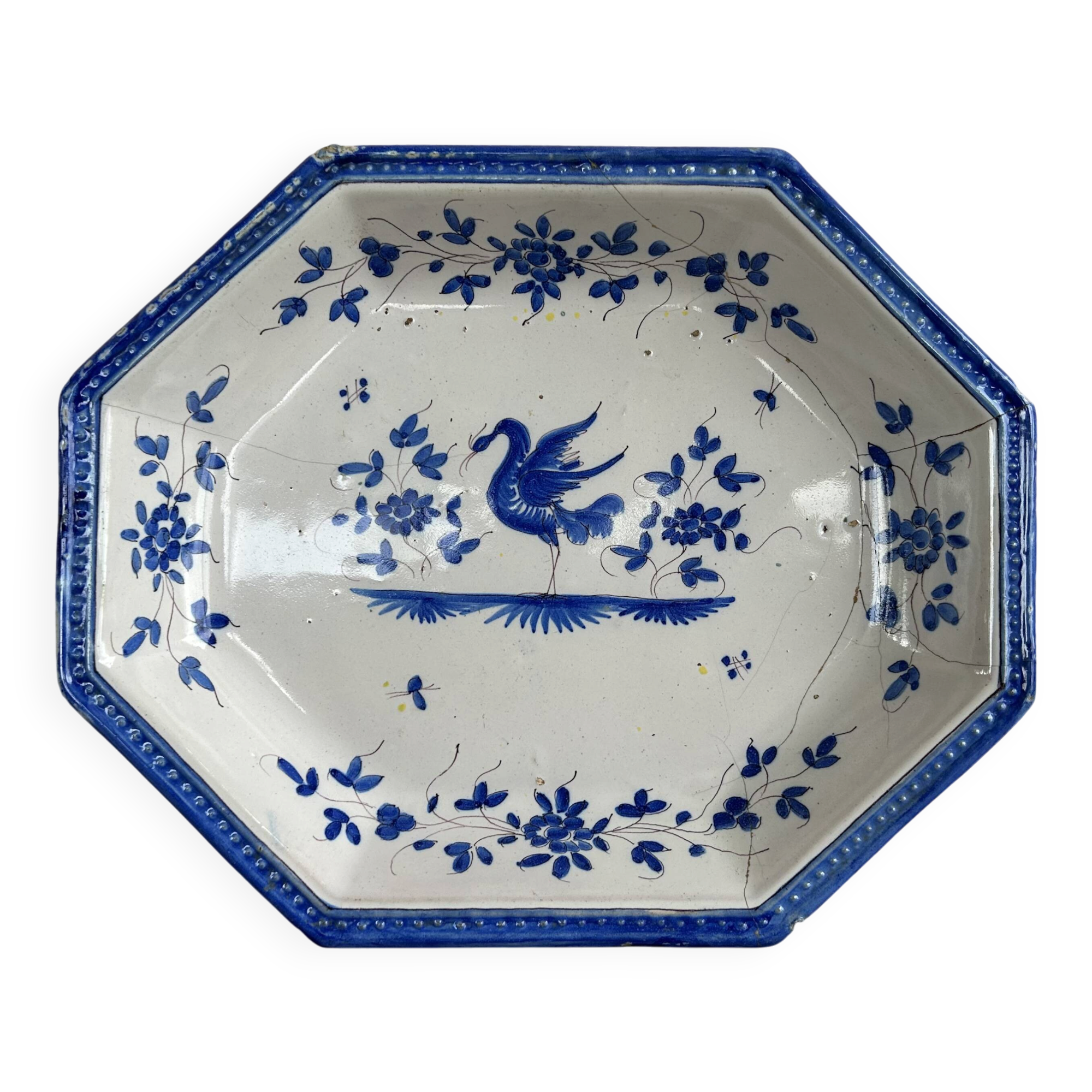 Antique octagonal plate in blue and white pottery with bird decoration.