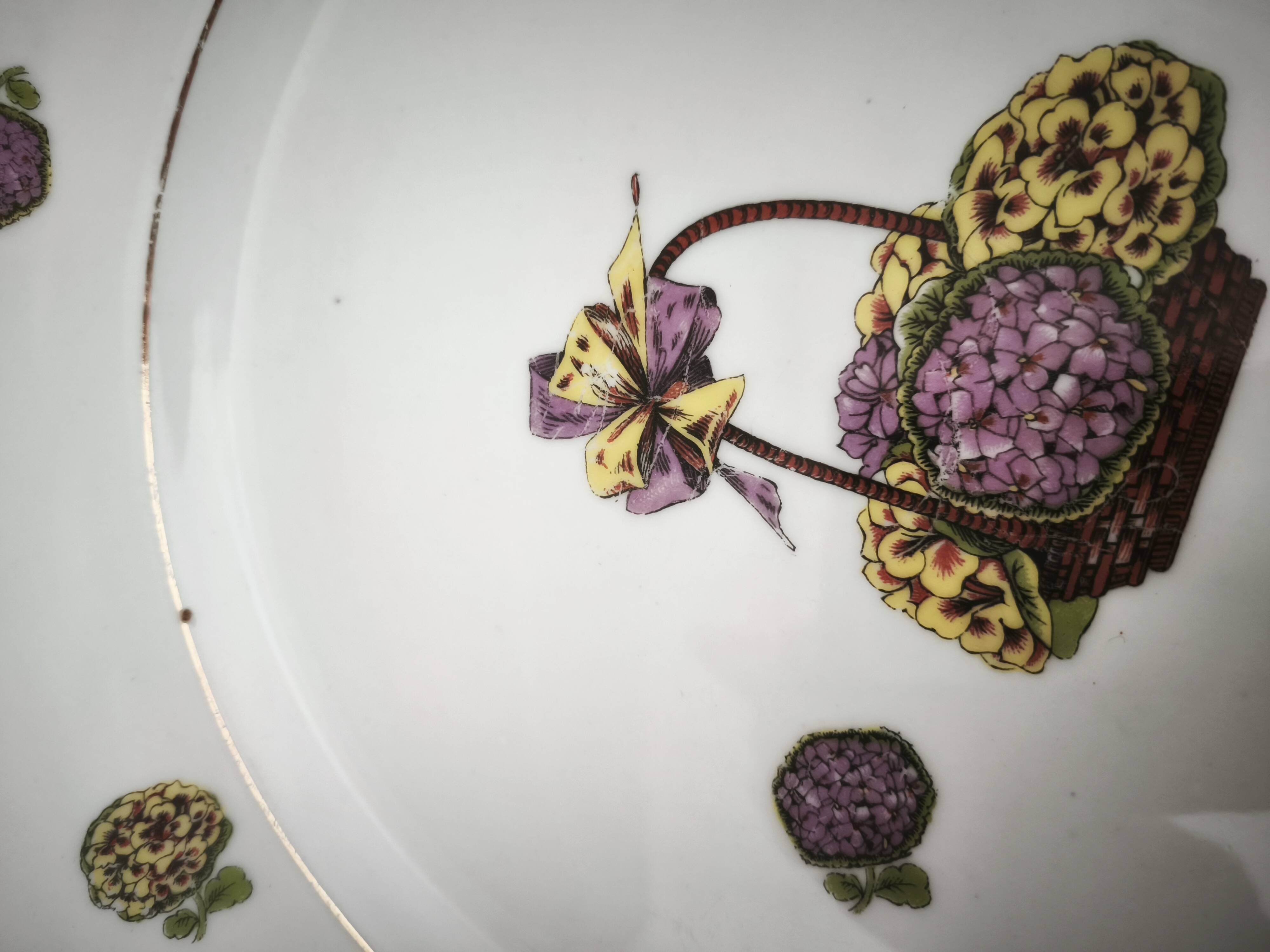 Round porcelain plate from Limoges with a hydrangea basket design.