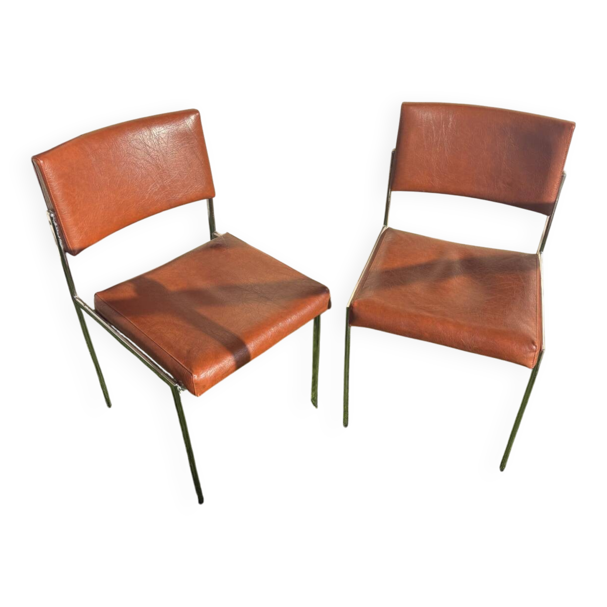A pair of vintage brown Skaï chairs.