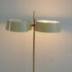Brass and lacquered metal floor lamp with a wooden magazine shelf.