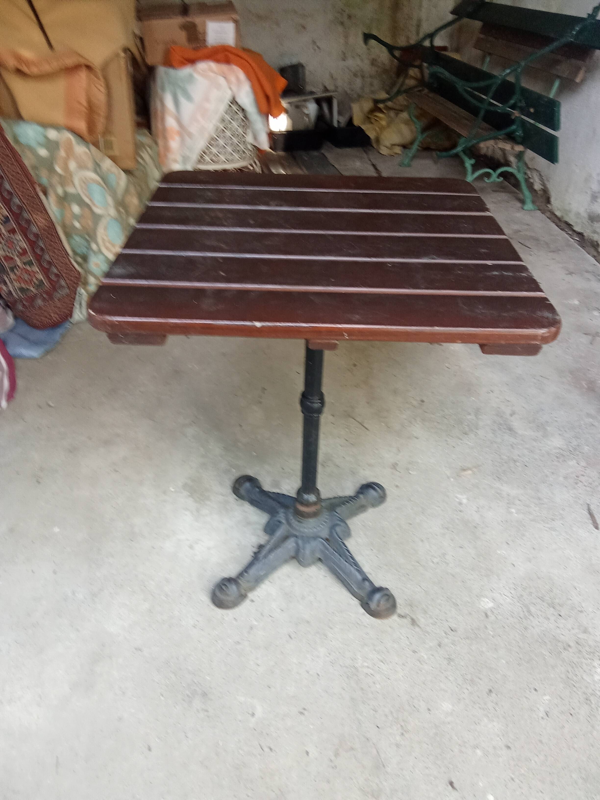Bistro table with a cast iron base and a wooden top.