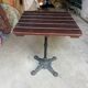 Bistro table with a cast iron base and a wooden top.