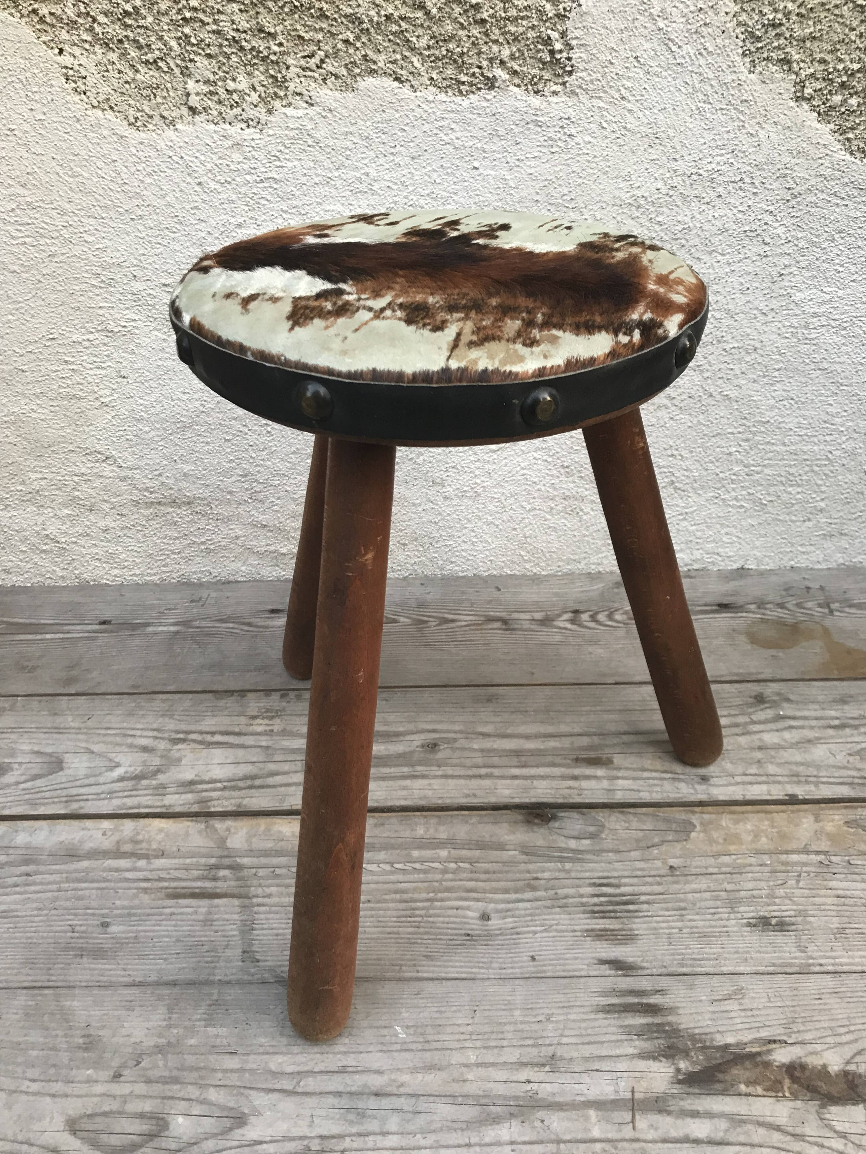 Old wooden tripod stool with seat leather vintage