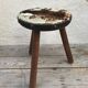 Old wooden tripod stool with seat leather vintage