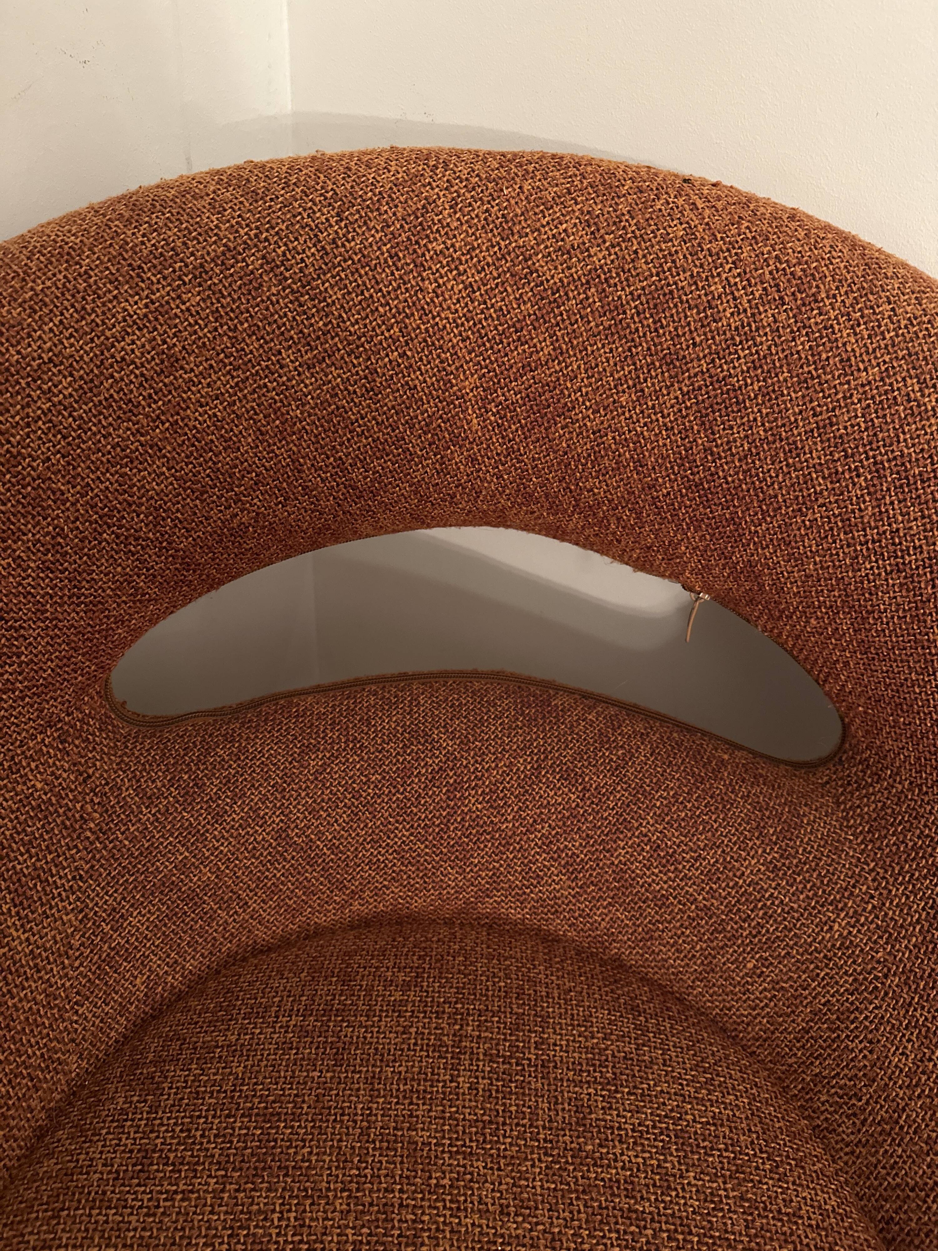 Circular armchair trimmed with orange fabric