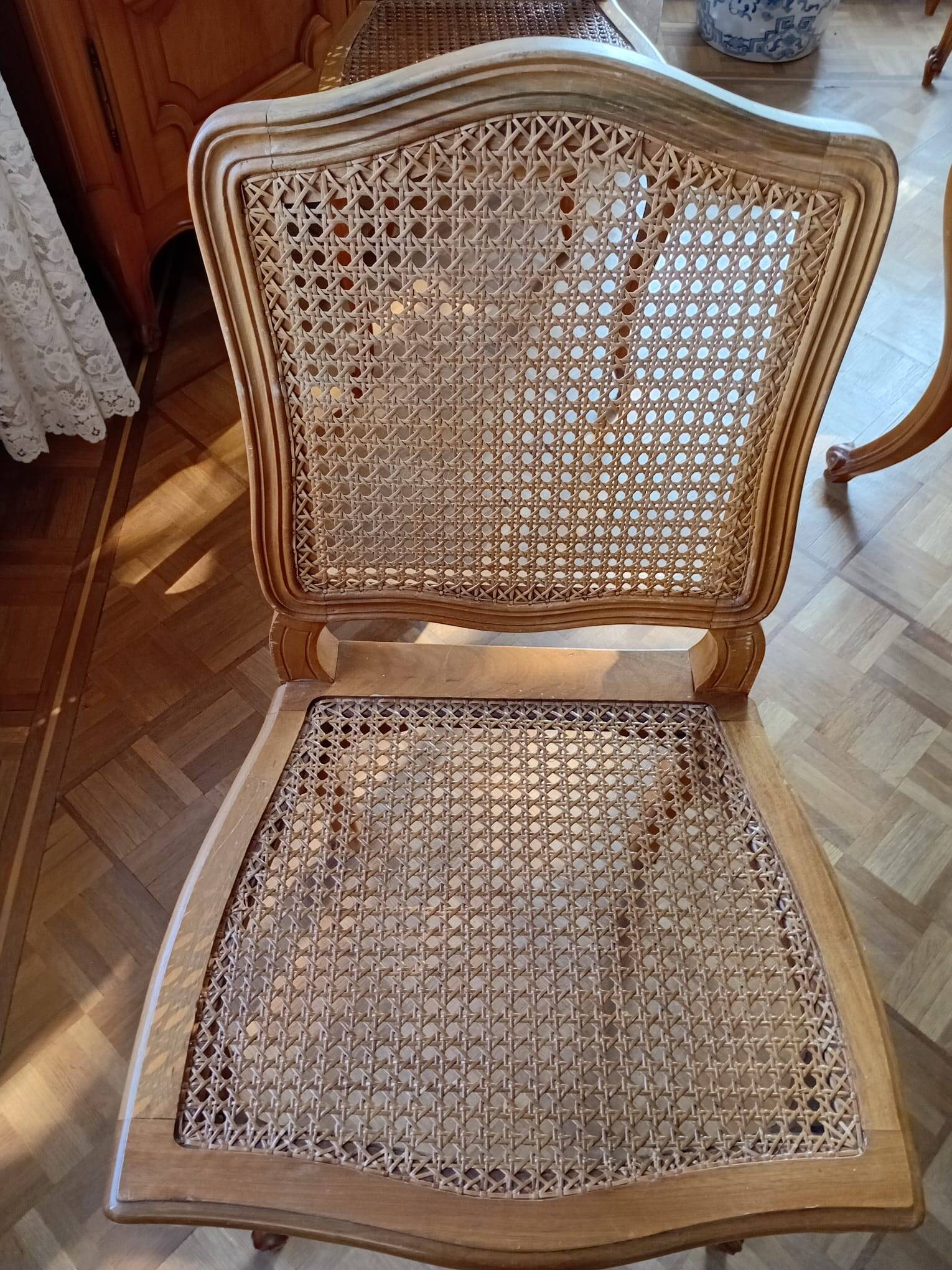 Carved wooden dining table and its 5 rattan caned chairs.