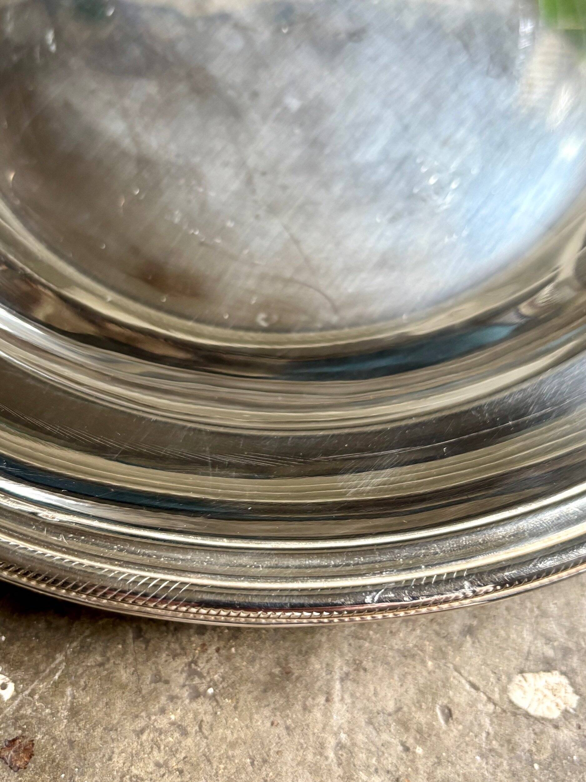 Round, hollow silver-plated metal dish