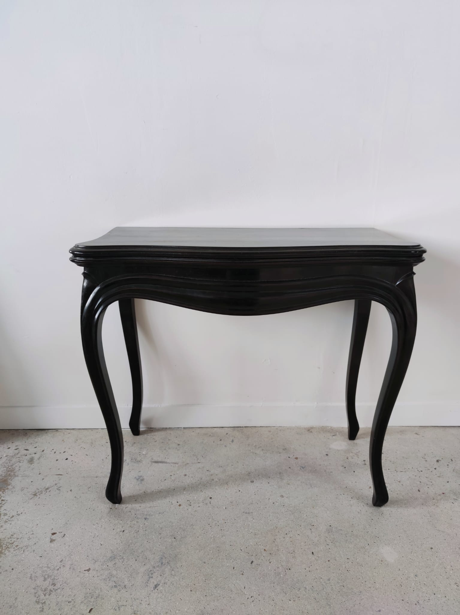 Molded blackened wooden play table, arched legs, green felt