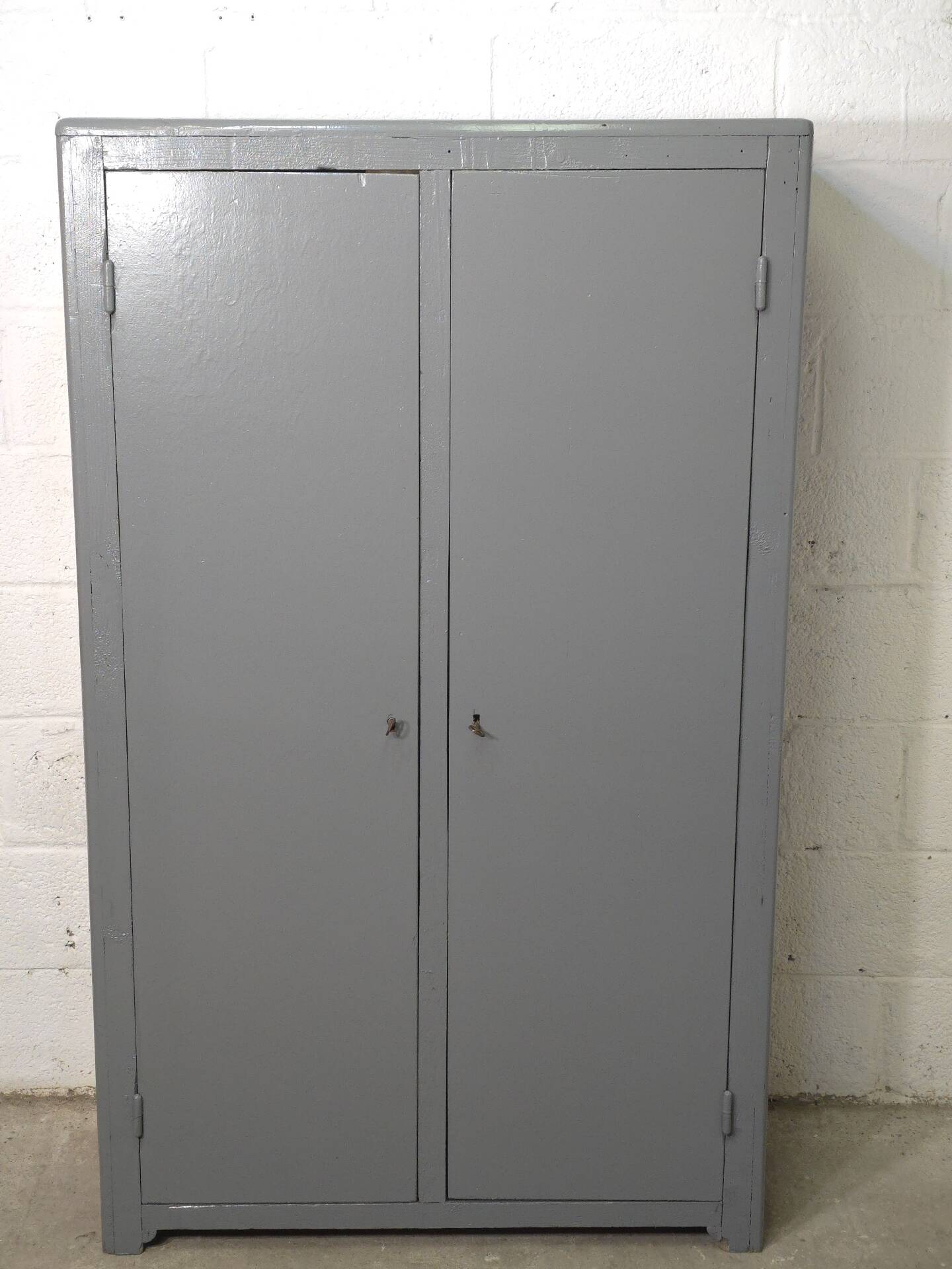 Curved wardrobe workshop locker made of wood repainted in grey.