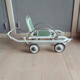 Old foldable stroller on metal wheels. Toy from the 50s