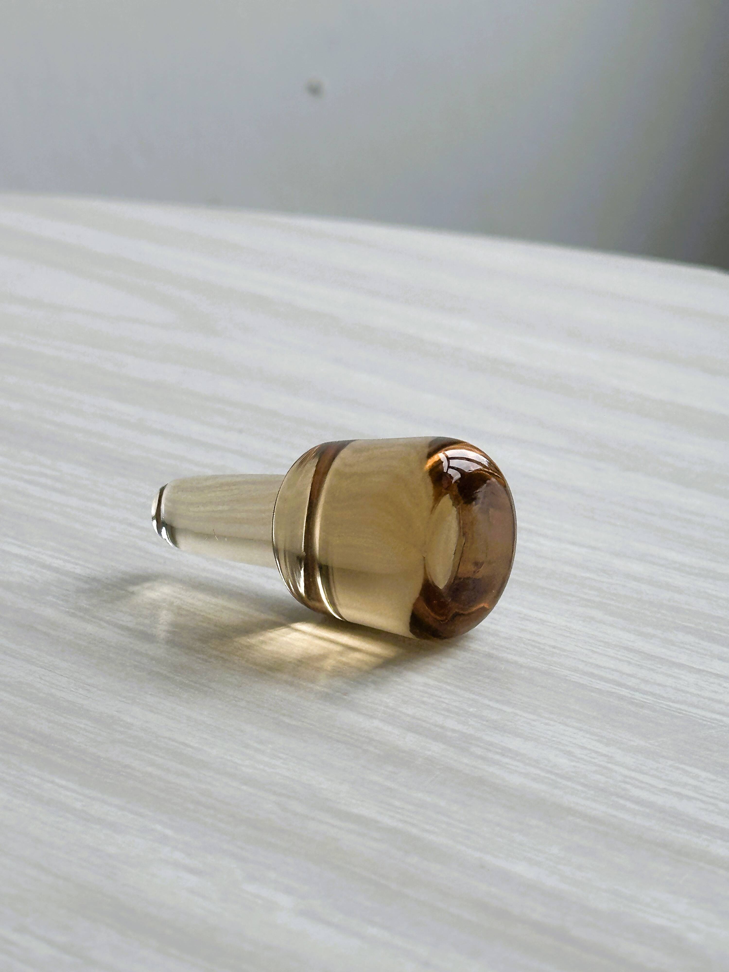 Translucent pinkish iridescent cracked glass bottle.