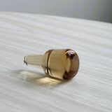 Translucent pinkish iridescent cracked glass bottle.