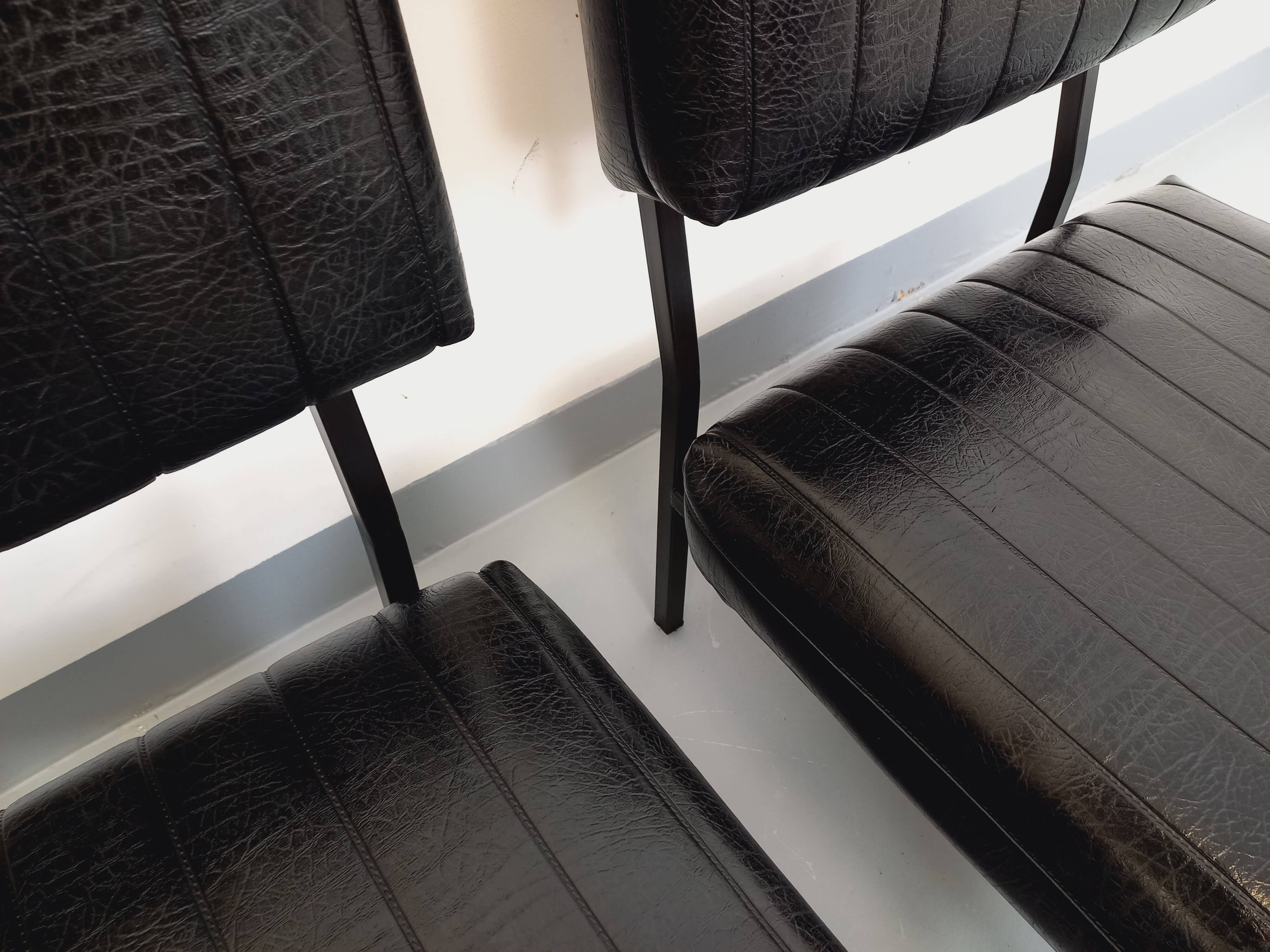 Set of 2 vintage modernist armchairs in black faux leather and metal.