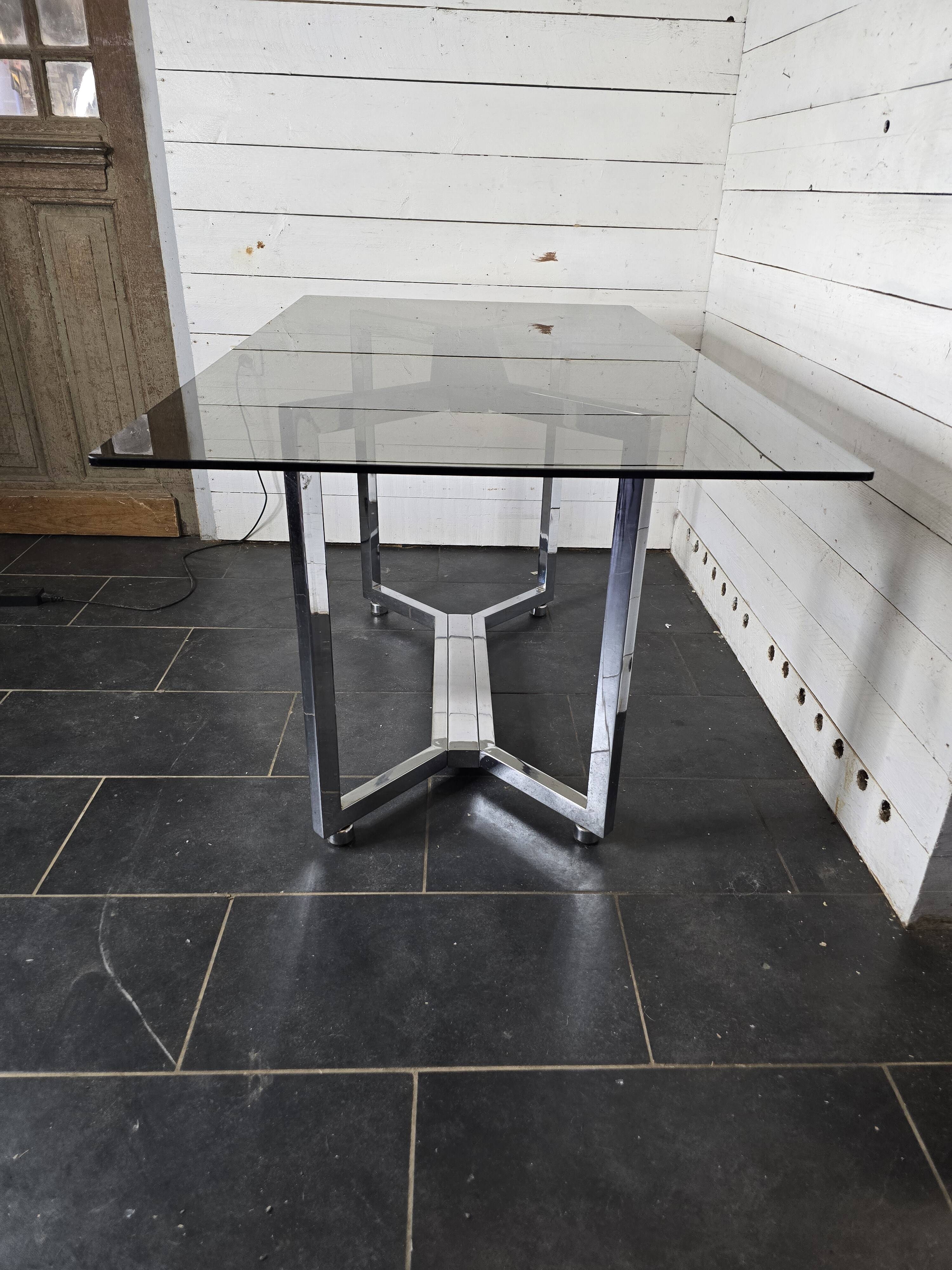 Table en métal chromé dessus verre fumé